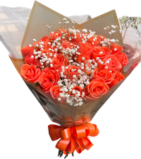 Regala un arreglo de rosas naranjas y gipso con un toque de follaje exótico. Disponible en BouquetsFlowers.com para entrega en Miami.