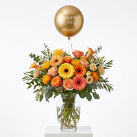 Golden Birthday Glow yellow, orange and peach floral arrangement in a glass vase with a gold Happy Birthday balloon.